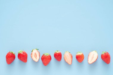 Taze çilekler mavi üzerine izole edilmiş.