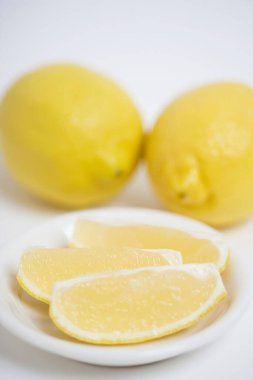 Bir limonu kapat ve beyaz bir tabakta dilimle.