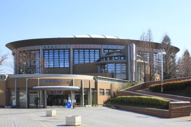 Büyük cam pencereleri ve merdivenleri olan modern dairesel bina.