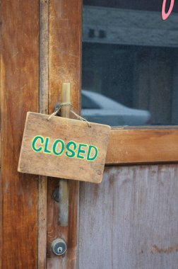 Tahta kapı tabelası girişte kapalı olduğunu gösteriyor.