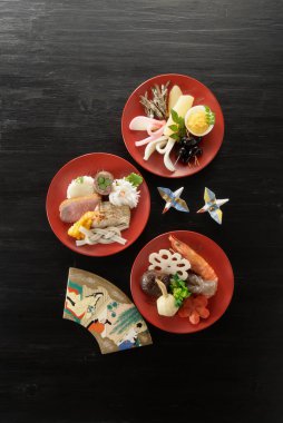 Masanın arkasında Japon yemekleri var.