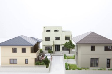 Beyaz arka plandaki küçük ev modelleri, ipotek kavramı