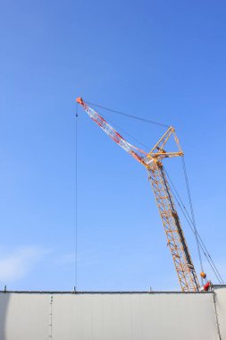 Mavi gökyüzü arka planında inşaat vincinin düşük açılı görüntüsü              