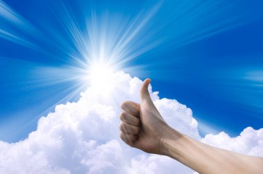 El, gökyüzü arkaplanına başparmak gösteriyor 