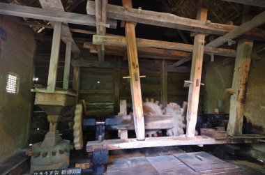 İçerideki eski ahşap makineler sade bir atölyenin iç mekanını aydınlatıyor.