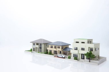 Beyaz arka plandaki küçük ev modelleri, ipotek kavramı