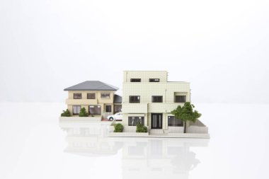 Beyaz arka plandaki küçük ev modelleri, ipotek kavramı