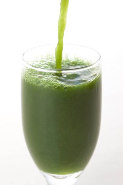 Açık arkaplana dökülen yeşil, taze, sağlıklı organik içeceğin yakın plan görüntüsü.                                          