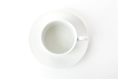 Beyaz arka planda beyaz çay tabağı ile beyaz seramik fincan.