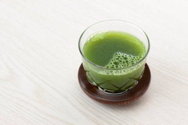 Açık arkaplanda yeşil, taze, sağlıklı organik içeceğin yakın plan görüntüsü.                                          