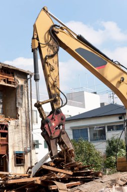 Ev inşaatının kaldırılması, endüstriyel binada çalışan kazıcı.                         