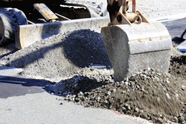 Kazıcı, inşaat alanının yakınlarında gevşek çakıl kazıyor.