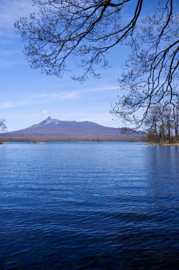 Güzel göl mavi gökyüzü ve bulutlar, arka planda manzaralı dağlar     