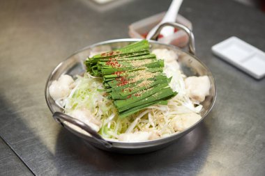 Baharatlı ve sebzeli metal kap.