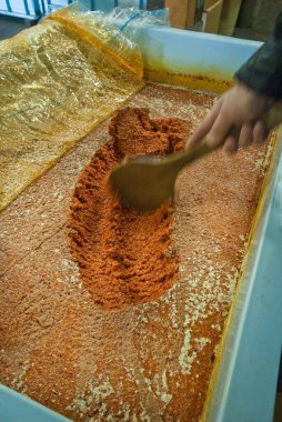 Turuncu baharat tozunu ahşap kaşık kabıyla karıştırıyorum.