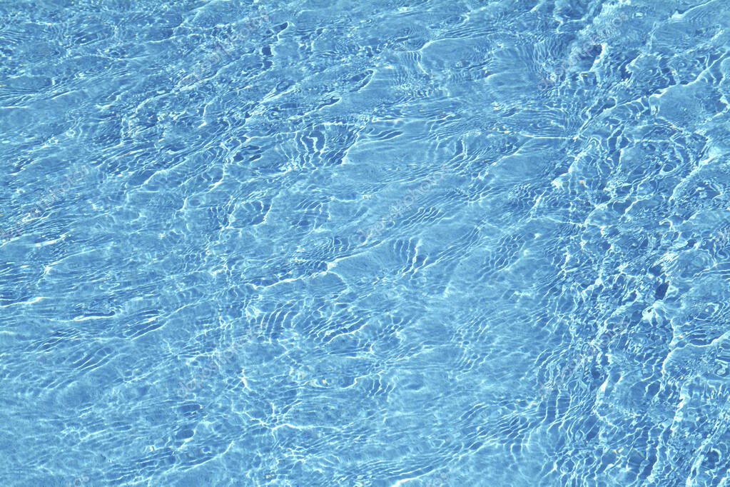 blue swimming pool water with ripples and reflection      