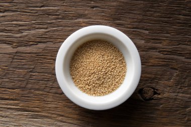 Beyaz kasenin içinde duran kuru maya tanecikleri.