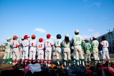 Gençlerin beyzbol takımları gündüz dışarıda duruyorlar.