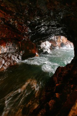 Güzel kayalık mağarası, hızlı akan suyu var.