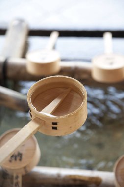 Tahta kepçe tapınak havzasında berrak suyun üzerinde dinleniyor.