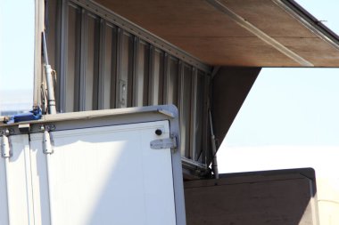 Açık metal konteynır. Açık hava güneşinin altında çatısı yükselmiş.