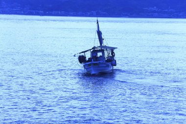 Denizde altın saatinde balıkçı teknesinin silueti