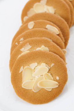 Beyaz zemin üzerinde badem olan lezzetli kurabiyelerin yakın plan görüntüsü             