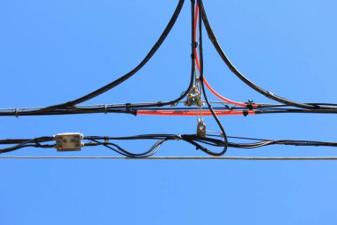 Mavi gökyüzünün arka planında yüksek voltajlı elektrik hatları