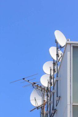 Çatıdaki uydu çanakları ve mavi gökyüzü.
