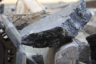 İnşaat alanında buldozer ve taş yığını.