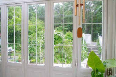 Büyük yeşil camlı beyaz bir evin penceresi.