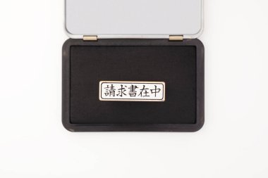 Beyaz zemin üzerinde kanji karakterleri olan siyah mürekkep taşı