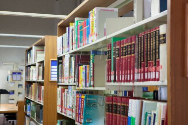 Üniversite kütüphanesinin içi kitaplık ve diğer mobilyalarla dolu