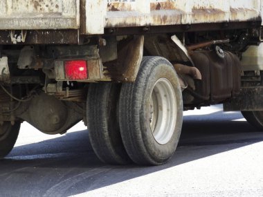 Şehirdeki asfalt yolda tekerlekleri olan bir kamyonun yakın çekimi.