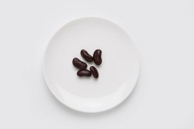 Beyaz tabakta siyah fasulye. en üstteki görünüm.