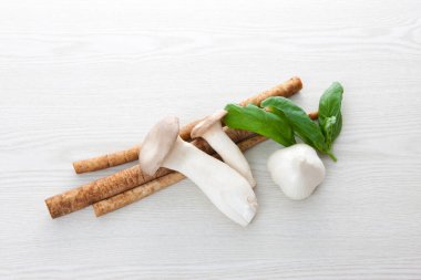 Taze çiğ sarımsak, mantar, ıspanak yaprağı ve beyaz arka planda Burdock kökü.