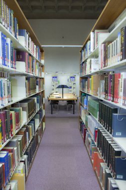 Üniversite kütüphanesinin içi kitaplık ve diğer mobilyalarla dolu