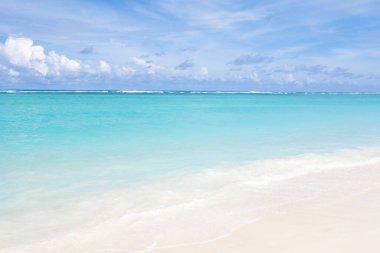 Tropikal tatil beldesindeki kumlu kumsal manzarası.