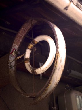 Tavandan sarkan paslı dairesel floresan lamba.