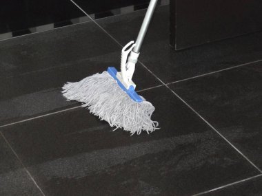 Oda köşesindeki koyu fayanslı paspas temizliği.