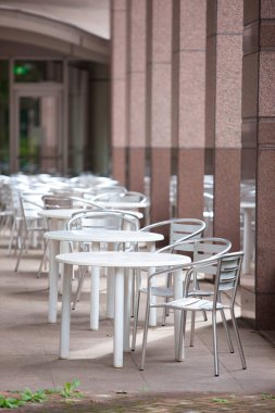 Masaları ve sandalyeleri olan açık hava kafesi.
