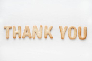 Beyaz arka planda izole edilmiş kurabiye mektuplarından oluşan teşekkür ederim.