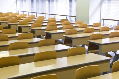 Ahşap sandalyeli boş modern sınıf manzarası ve ahşap masalar..