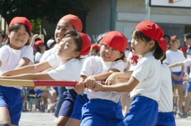 Okul bahçesinde aktif spor müsabakası olan üniformalı Asyalı çocuklar 