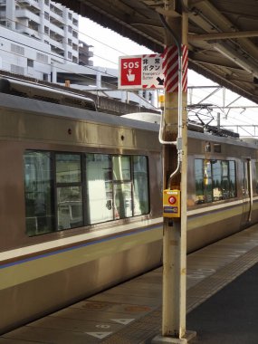 Tren, şehirdeki platformda hareketsiz duruyor.