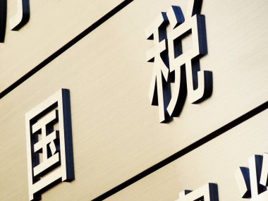 Modern bina duvarında cesur Çince karakterleri gösteren yakın plan.