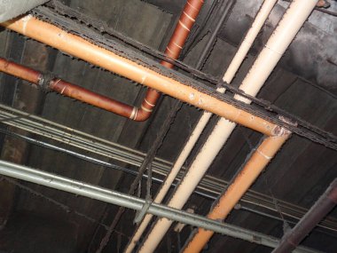 Terk edilmiş eski binada tavanın altındaki borular. 