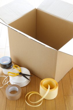 Bantla ve makasla çevrili boş karton kutu