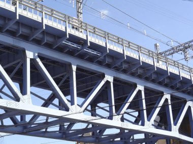 Yüksek voltajlı demiryolu hatları. Mavi gökyüzü arkaplanındaki elektrik iletim hatları.        