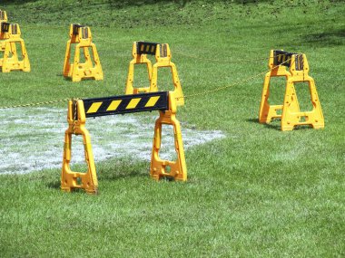 Yeşil çim tarlasına sarı güvenlik bariyerleri yerleştirildi